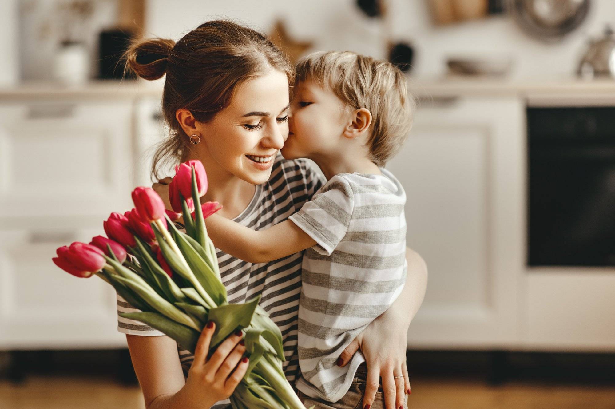 happy mother's day! child son gives flowers for  mother on holiday